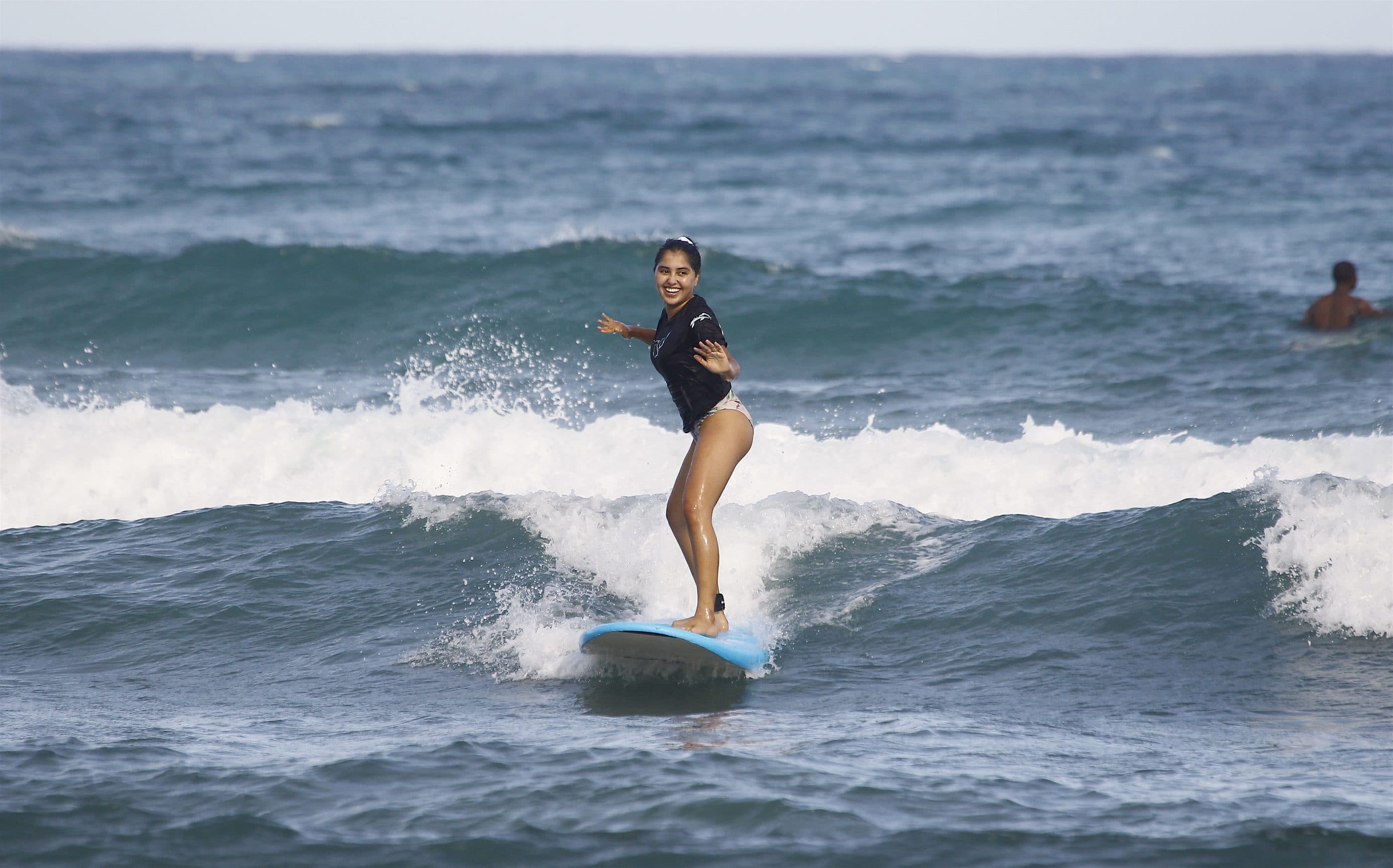 Une surfeuse prend sa vague en Guadeloupe